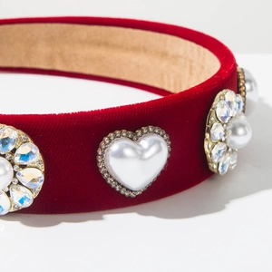 Macro view of red velvet headband featuring heart-shaped pearls and rhinestone floral details
