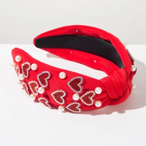 Detail of red knotted headband with rhinestone hearts and pearls for Valentine's Day