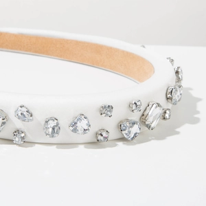 Detail of white satin headband with sparkling crystal heart and drop rhinestones in silver claws