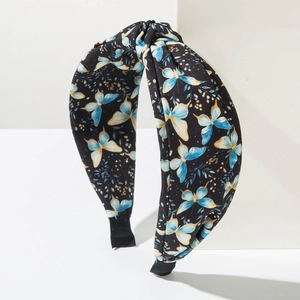 Détail du serre-tête avec imprimé papillon et design de nœud torsadé élégant