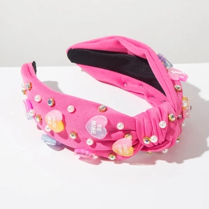 Detail of pink knotted headband with heart charms, pearls and colorful rhinestones