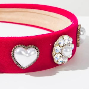 Close-up of red velvet headband with exquisite pearl heart and rhinestone floral details