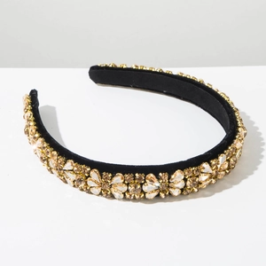 Close-up of luxury Baroque headband with gold and amber crystals on black velvet base