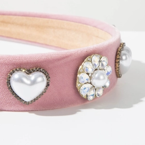 Detailed view of pink velvet headband with pearl heart and rhinestone floral accents