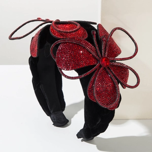 Detailed macro view of vintage red rhinestone flowers on a black velvet padded headband