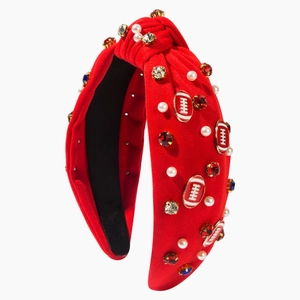 Red knotted headband with crystals, pearls and football charms on a white background