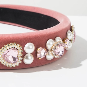 Detail eines rosa Samt-Haarreifs mit Kristallherz, Perlen und funkelnden Strasssteinen