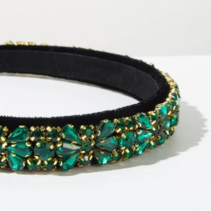 Detailed macro view of emerald crystals on a luxury black velvet baroque headband