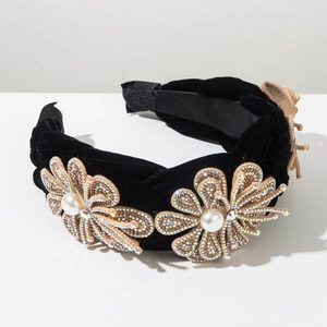 Détails d'un serre-tête en velours tressé avec des fleurs en strass et perles baroques