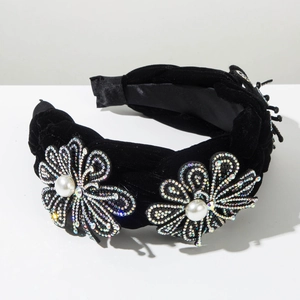 Détail du serre-tête en velours avec fleurs en strass faites main et perles nacrées