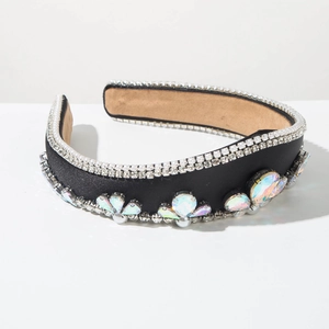 Dettaglio di un cerchietto di lusso con perle bianche e cristalli iridescenti