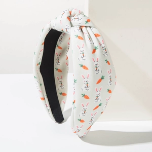 Detail view of Easter knotted headband with rabbit and carrot patterns on beige fabric