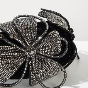 Close-up of black velvet headband with sparkling silver rhinestone flower detail