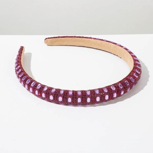 Detail view of red rhinestone padded headband featuring luxury purple crystal gems