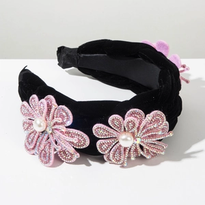 Détail du serre-tête en velours avec fleurs en strass roses et perles blanches