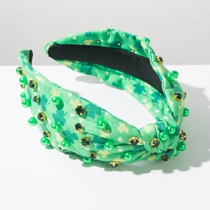 Macro shot of clover patterns with green pearls and rhinestones on the knotted headband