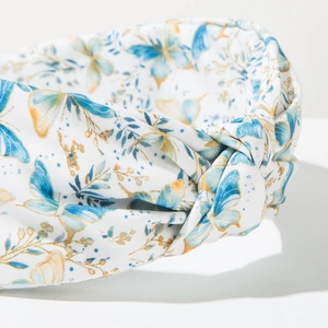 Gros plan sur le serre-tête bleu ciel avec motifs papillons et texture torsadée