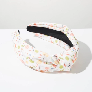 Detail of Easter headband featuring colorful egg and bunny prints on white knotted fabric