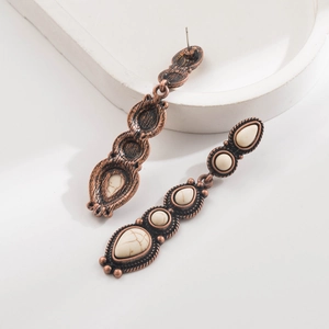 Vista dettagliata di orecchini vintage in bronzo boho con pietre turchesi bianche