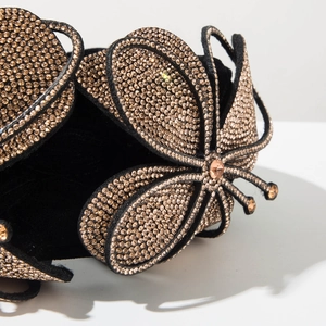 Detailed close-up of champagne rhinestones and black velvet on the butterfly hairband
