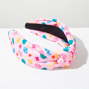 Detail of pink Easter headband with bunny egg patterns and a stylish top knot