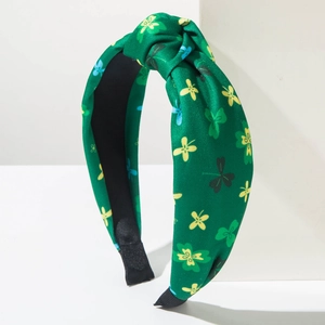Detail of St. Patrick's Day knotted headband with green shamrock prints and soft fabric