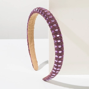 Close-up of purple rhinestone headband with plush lining and shimmering crystal details