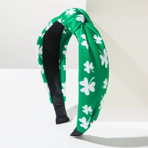 Green St. Patrick's Day headband with white clover patterns and top knot design