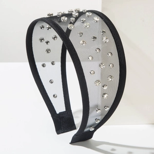 Close-up of black tulle headband featuring sparkling rhinestones on wide mesh fabric