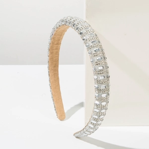 Detailed view of hand-set square rhinestones on a wide silver fashion headband