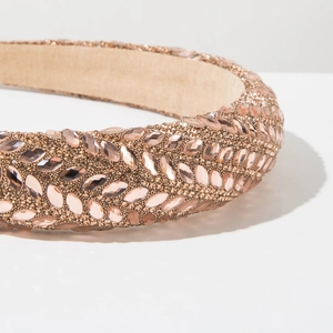 Makroaufnahme von Luxus-Haarreif mit champagnerfarbenen Strasssteinen und Perlen