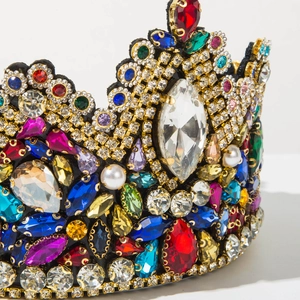 Close-up of luxury Baroque crown featuring colorful rhinestones and white pearls on gold base
