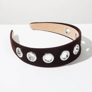 Detail of wide brown velvet headband with silver metal eyelets and premium baroque style