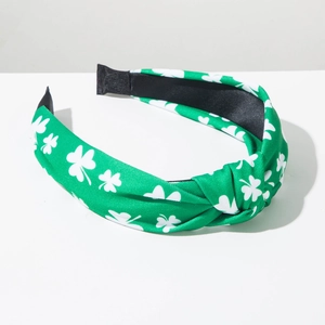 Detail of green St. Patrick's Day knotted headband with white clover prints on fabric