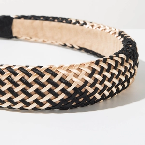 Close-up of hand-woven black and champagne gold raffia headband with premium texture