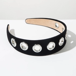 Detail view of a black velvet headband with silver metal eyelets and non-slip inner lining