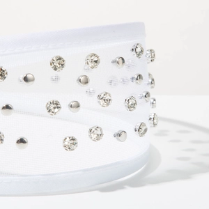 Close-up of white tulle headband with sparkling rhinestones and silver metallic rivets