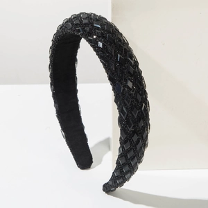 Detail view of black wide headband with sparkling crystal rhinestones on geometric display