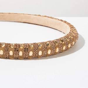 Detailed macro view of champagne gold sponge headband with shimmering crystals and rhinestones
