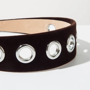 Detail of dark brown velvet headband featuring large silver metal grommet eyelets
