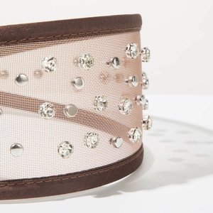 Detail of brown tulle headband featuring sparkling crystals and silver metal rivets