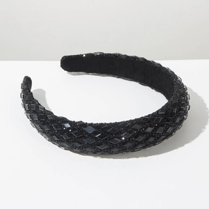 Detail of luxury wide headband featuring densely inlaid black crystals and matte inner lining