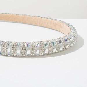 Close-up of sparkling rhinestone padded headband with iridescent crystals on white backdrop