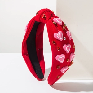 Rode geknoopte haarband met roze hartjes en kristallen op een witte achtergrond