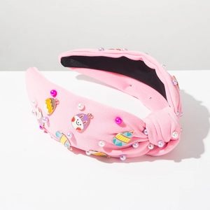 Detailed view of pink knotted headband with Easter egg and rabbit enamel charms