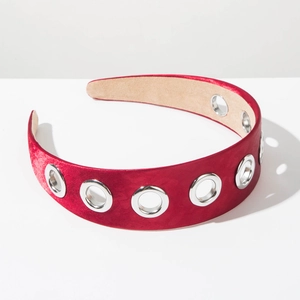 Detail of red velvet headband with silver metal eyelet texture in retro industrial style