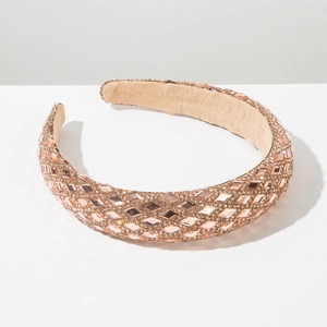 Detail of rose gold padded headband featuring sparkling diamond-cut crystal embellishments