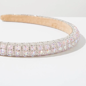 Close-up of padded headband with white crystals and iridescent star-shaped rhinestones