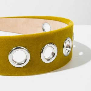 Detailed macro view of mustard yellow velvet wide headband with silver metal grommets
