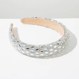 Close-up of wide rhinestone headband with silver crystals and beige velvet lining